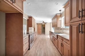 10235 White Rock Road Conroe, TX 77306 - Photo 3 of 25 a kitchen with granite countertop a refrigerator a sink and wooden floor
