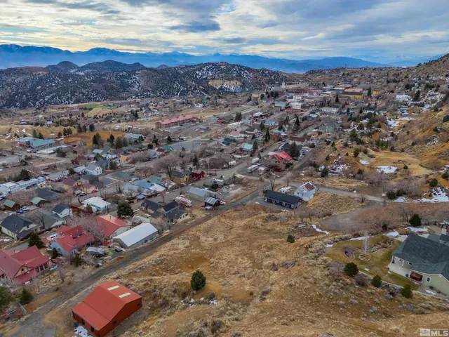 a view of a dry yard with wooden fence