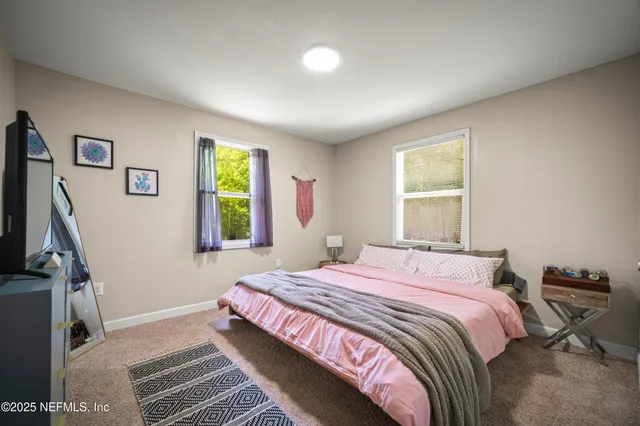 a bedroom with a bed desk and a window