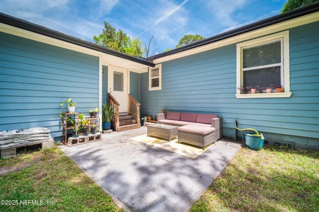 a view of a patio with a table and chairs and potted plants