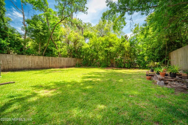 a view of yard with swimming pool and trees in the background