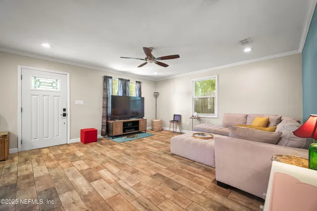 a living room with furniture a flat screen tv and a window