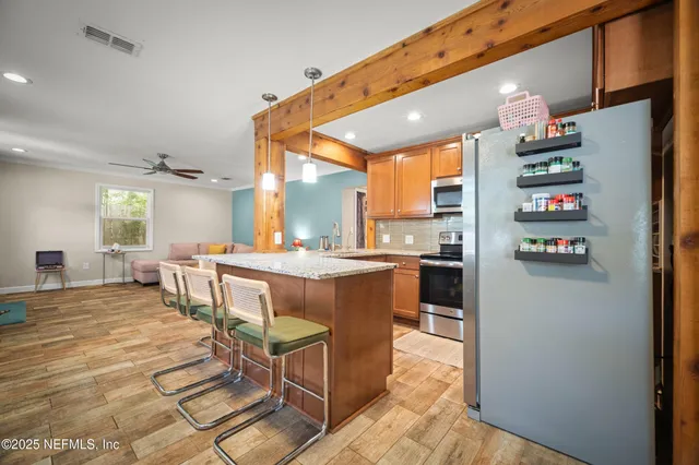 a dining hall with stainless steel appliances a dining table and chairs