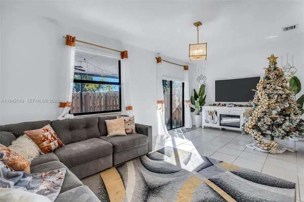 a living room with furniture a flat screen tv and a large window