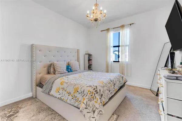 a bedroom with a bed and a flat tv screen on dresser