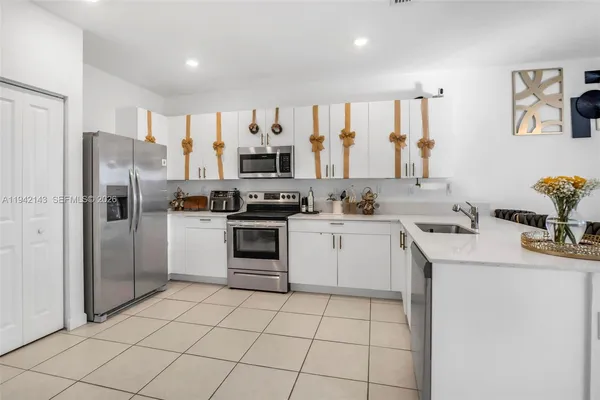 a kitchen with a sink a refrigerator and cabinets