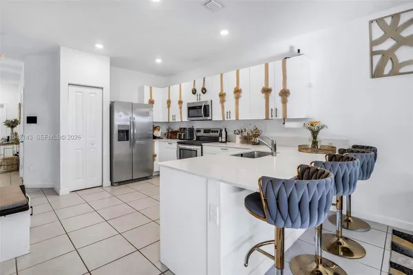 a kitchen with stainless steel appliances kitchen island granite countertop a refrigerator and a stove top oven