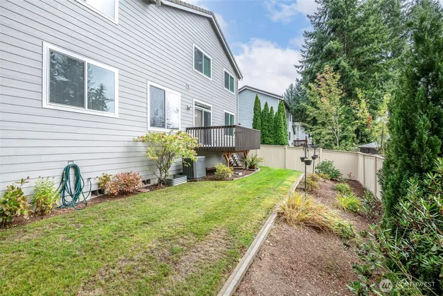 a view of a backyard with fountain plants and large tree