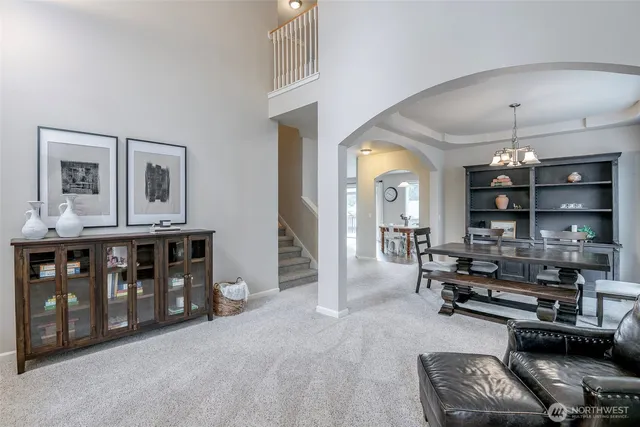 a living room with furniture a dining table and chairs with wooden floor