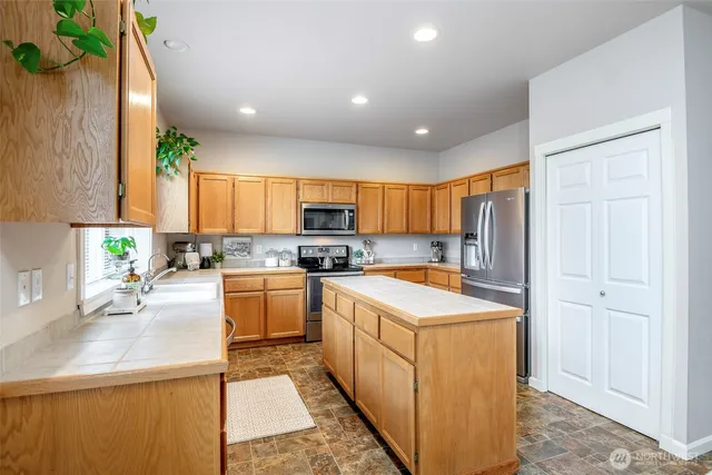 a kitchen with a sink a stove a refrigerator and cabinets