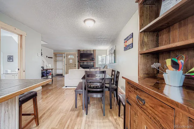 a kitchen with stainless steel appliances granite countertop a stove top oven a dining table and chairs with wooden floor