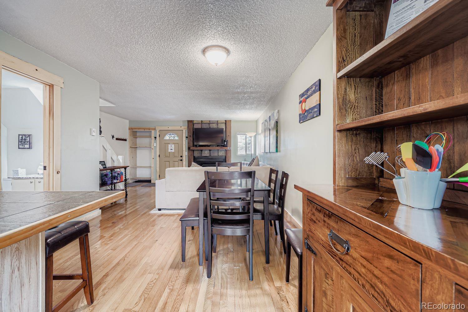 6916 Ryan Gulch Road, Unit 6916 Silverthorne, CO 80498 - Photo 11 of 33 a kitchen with stainless steel appliances granite countertop a stove top oven a dining table and chairs with wooden floor
