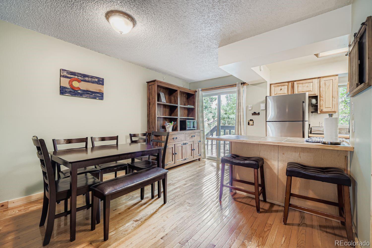 6916 Ryan Gulch Road, Unit 6916 Silverthorne, CO 80498 - Photo 12 of 33 a kitchen with stainless steel appliances granite countertop a table chairs a stove a sink and a refrigerator