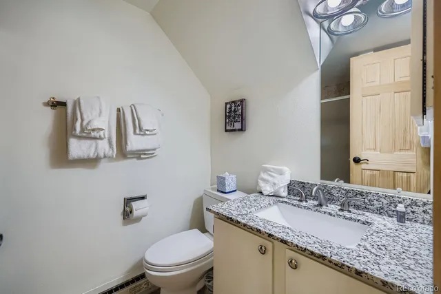 a bathroom with a granite countertop sink a toilet and a mirror