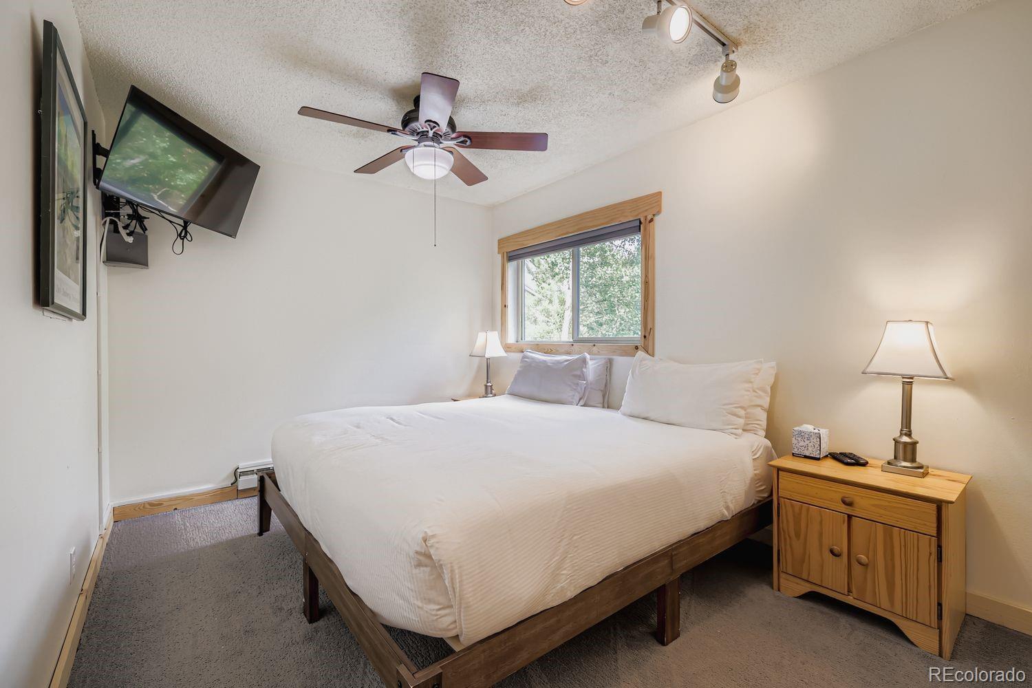 6916 Ryan Gulch Road, Unit 6916 Silverthorne, CO 80498 - Photo 15 of 33 a bedroom with a bed and a chandelier