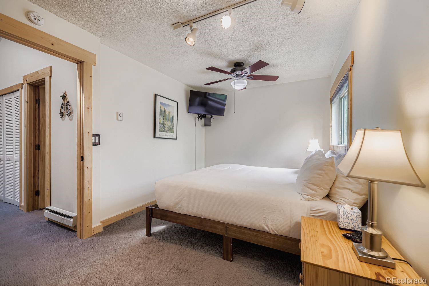 6916 Ryan Gulch Road, Unit 6916 Silverthorne, CO 80498 - Photo 16 of 33 a bedroom with a bed and a chandelier