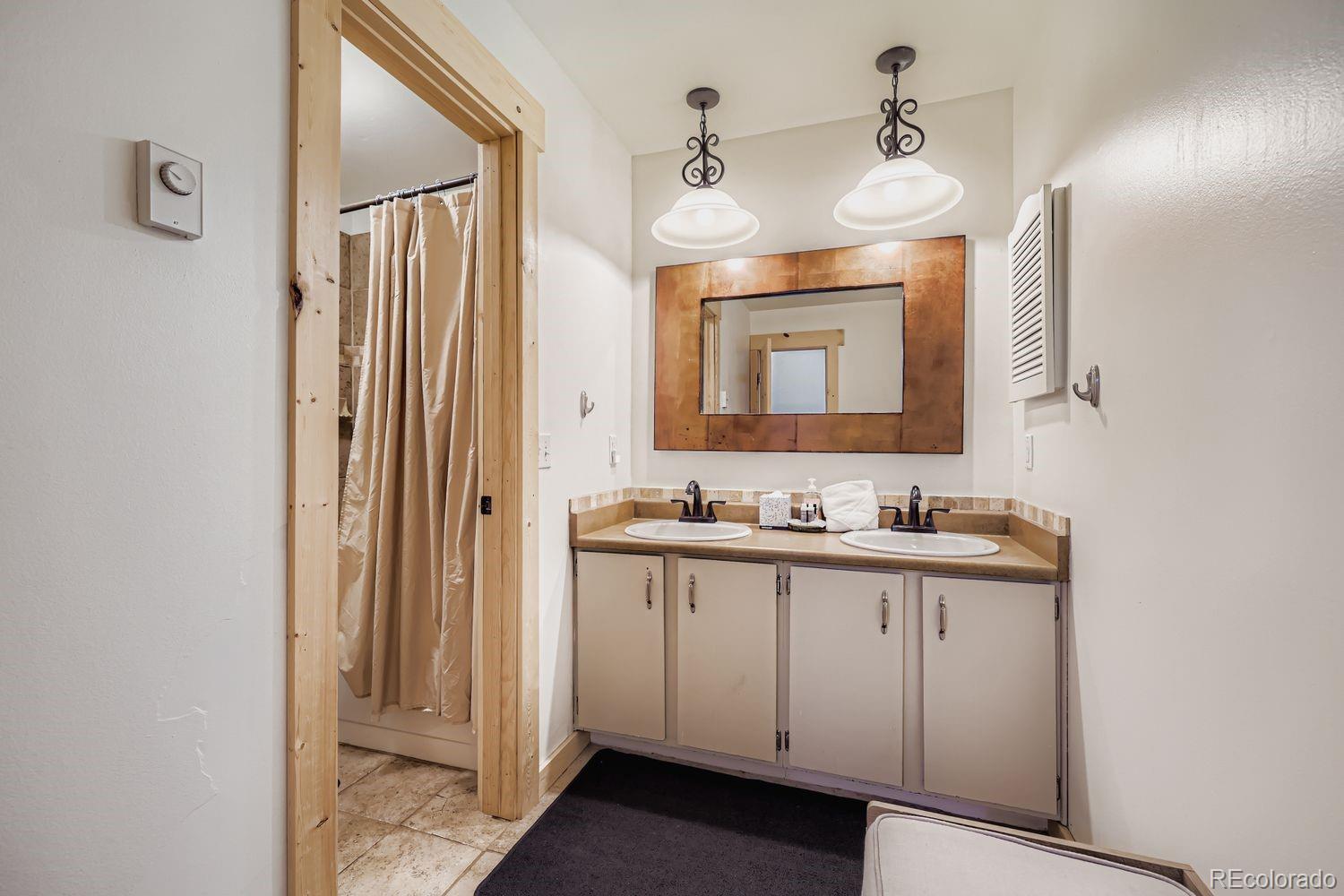 6916 Ryan Gulch Road, Unit 6916 Silverthorne, CO 80498 - Photo 18 of 33 a bathroom with a double vanity sink and mirror