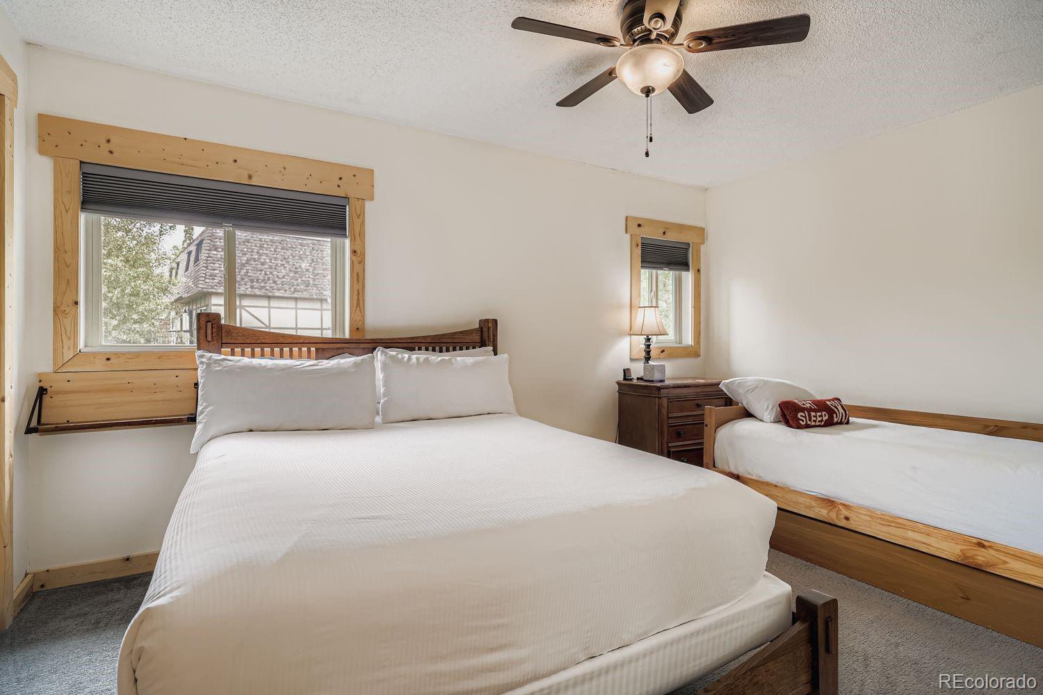 6916 Ryan Gulch Road, Unit 6916 Silverthorne, CO 80498 - Photo 21 of 33 a bedroom with a bed and a chandelier