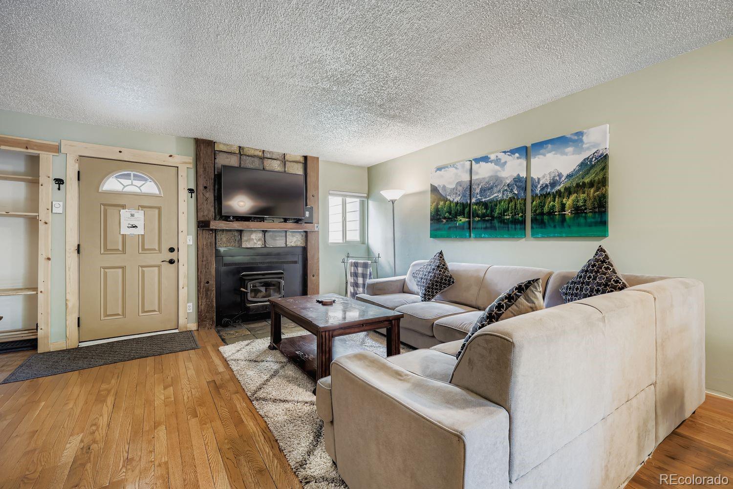 6916 Ryan Gulch Road, Unit 6916 Silverthorne, CO 80498 - Photo 5 of 33 a living room with furniture a fireplace and a flat screen tv