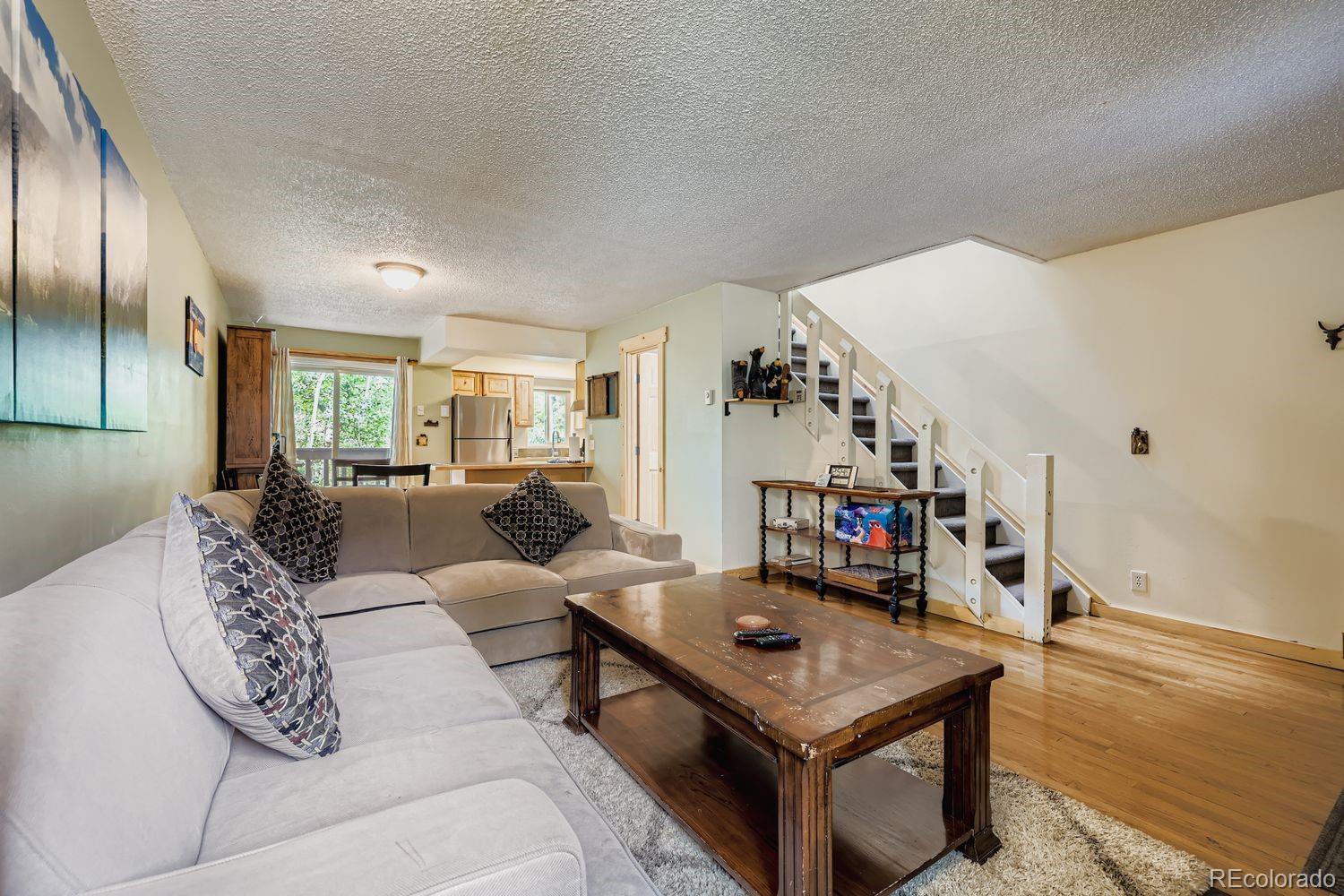 6916 Ryan Gulch Road, Unit 6916 Silverthorne, CO 80498 - Photo 7 of 33 a living room with furniture and wooden floor