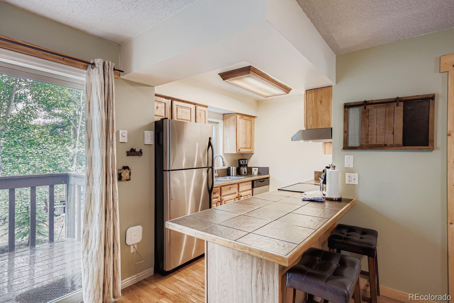 6916 Ryan Gulch Road, Unit 6916 Silverthorne, CO 80498 - Photo 8 of 33 a kitchen with stainless steel appliances a refrigerator and a stove top oven