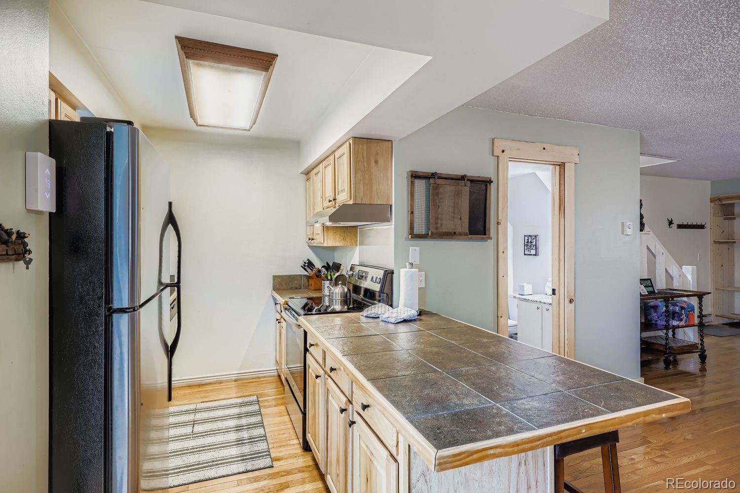 6916 Ryan Gulch Road, Unit 6916 Silverthorne, CO 80498 - Photo 9 of 33 a kitchen with stainless steel appliances granite countertop a refrigerator a stove and a sink