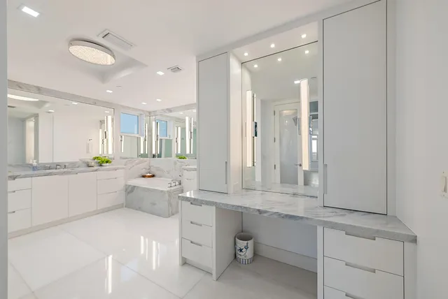a bathroom with a double vanity sink mirror and a bathtub