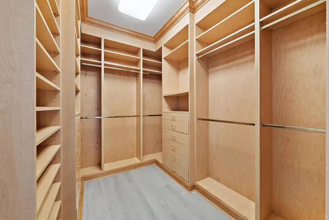 a view of walk in closet with empty racks