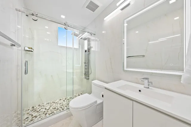 a bathroom with a sink a toilet and shower