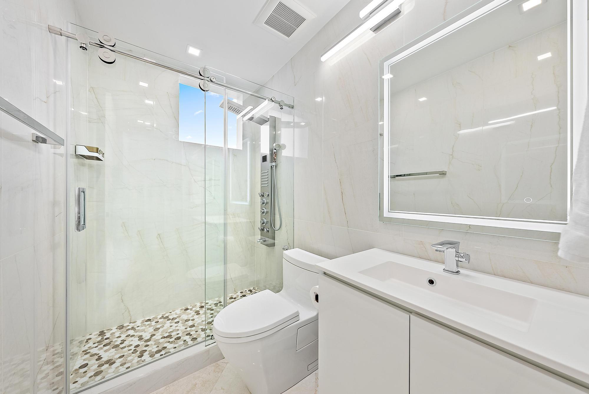 Undisclosed Address Boca Raton, FL 33431 - Photo 31 of 47 a bathroom with a sink a toilet and shower