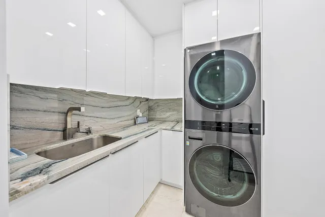 a utility room with sink dryer and washer