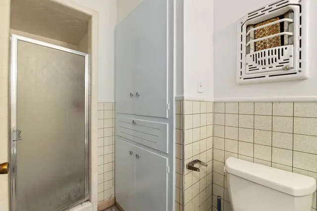 a bathroom with a toilet and a shower