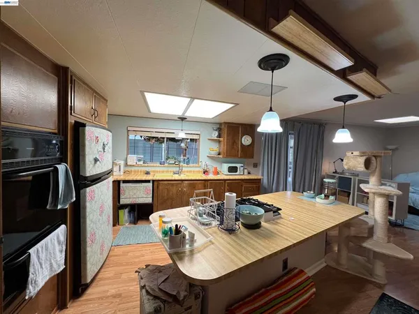 a kitchen with a dining table chairs stainless steel appliances and cabinets