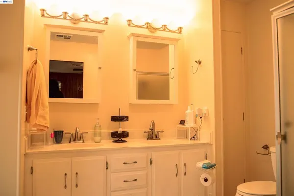 a bathroom with a granite countertop sink and a mirror