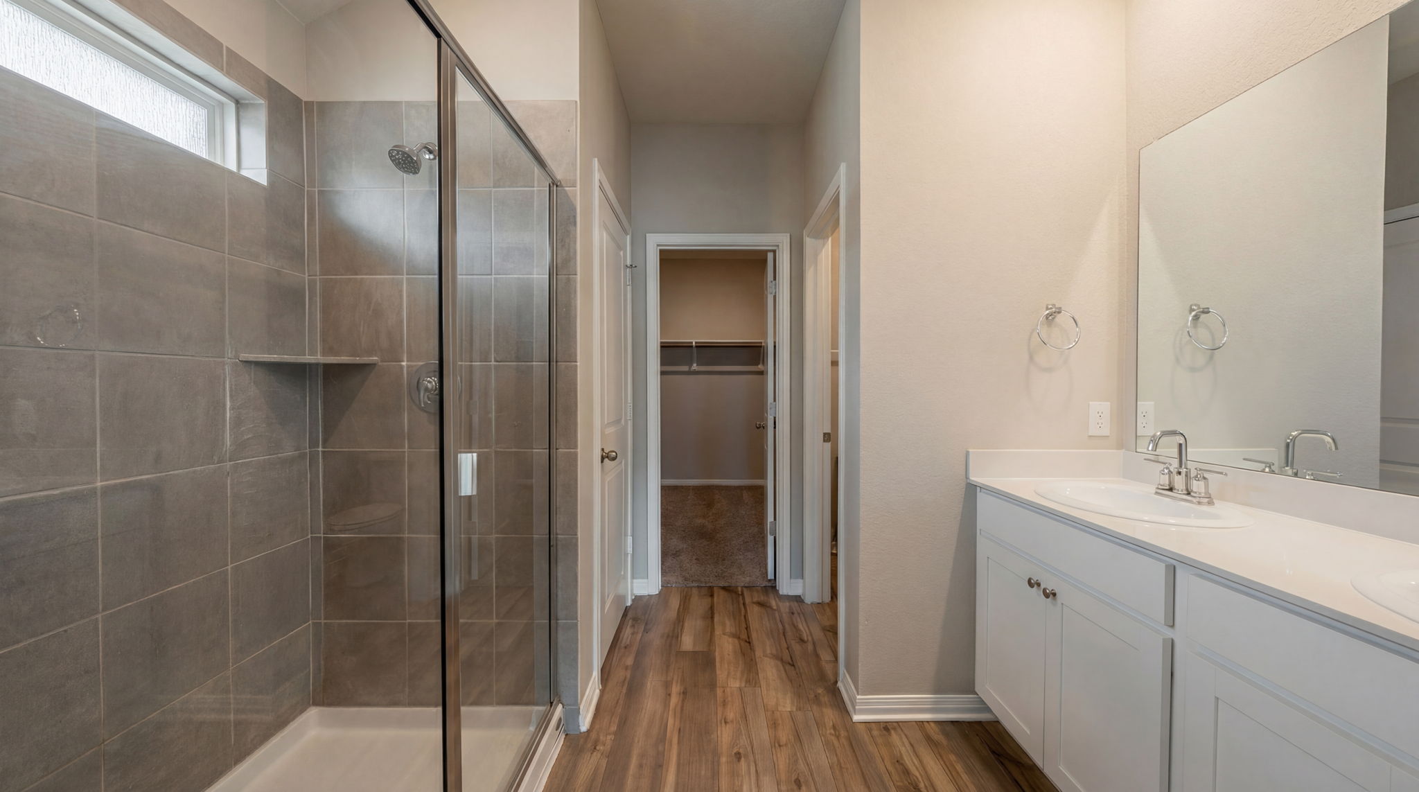 1003 Round Bale Road Hutto, TX 78634 - Photo 6 of 29 Full bath featuring double vanity, a walk in closet, dark wood-type flooring, and a stall shower