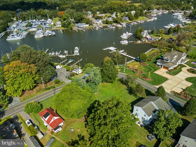 an aerial view of residential houses with outdoor space and lake view