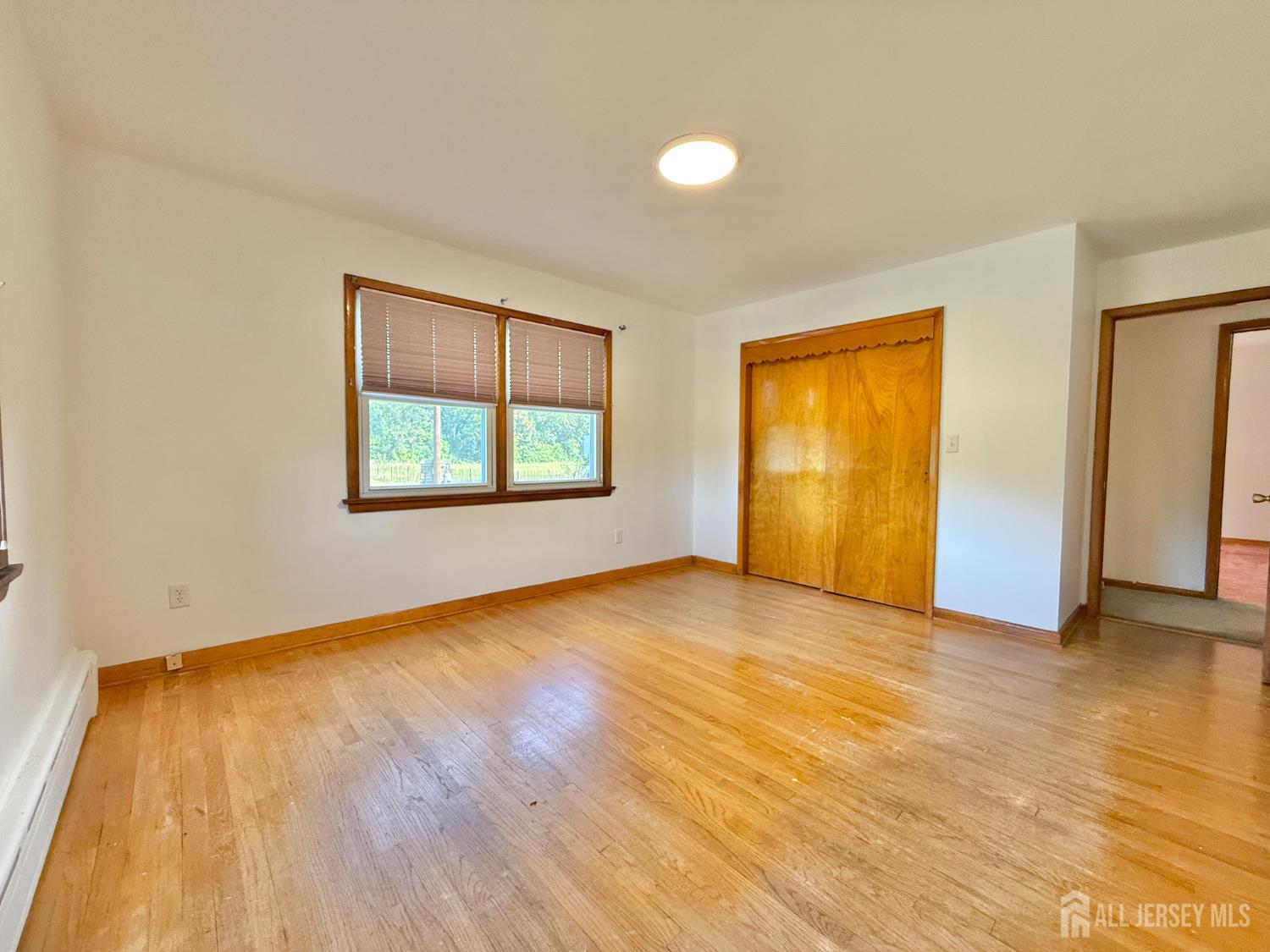 452 Cranbury Road East Brunswick, NJ 08816 - Photo 7 of 16 a view of an empty room with wooden floor and a window