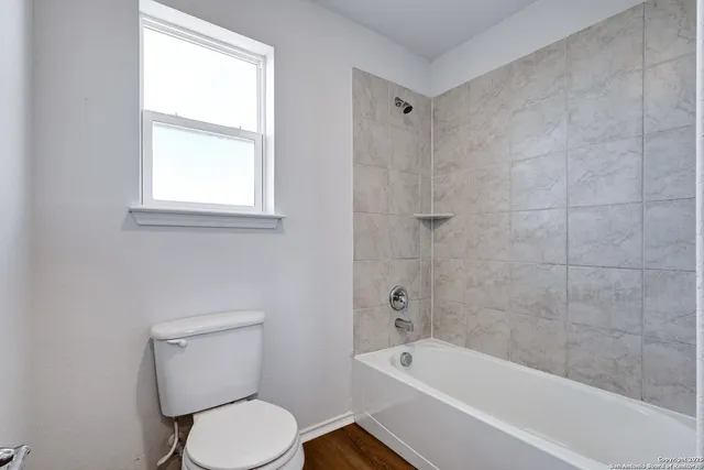 a bathroom with a toilet bathtub and window