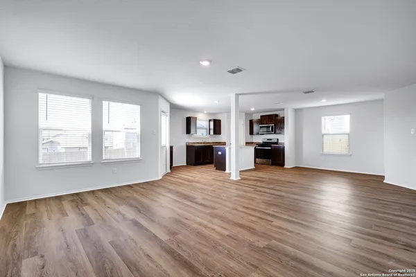 an empty room with kitchen fireplace and windows