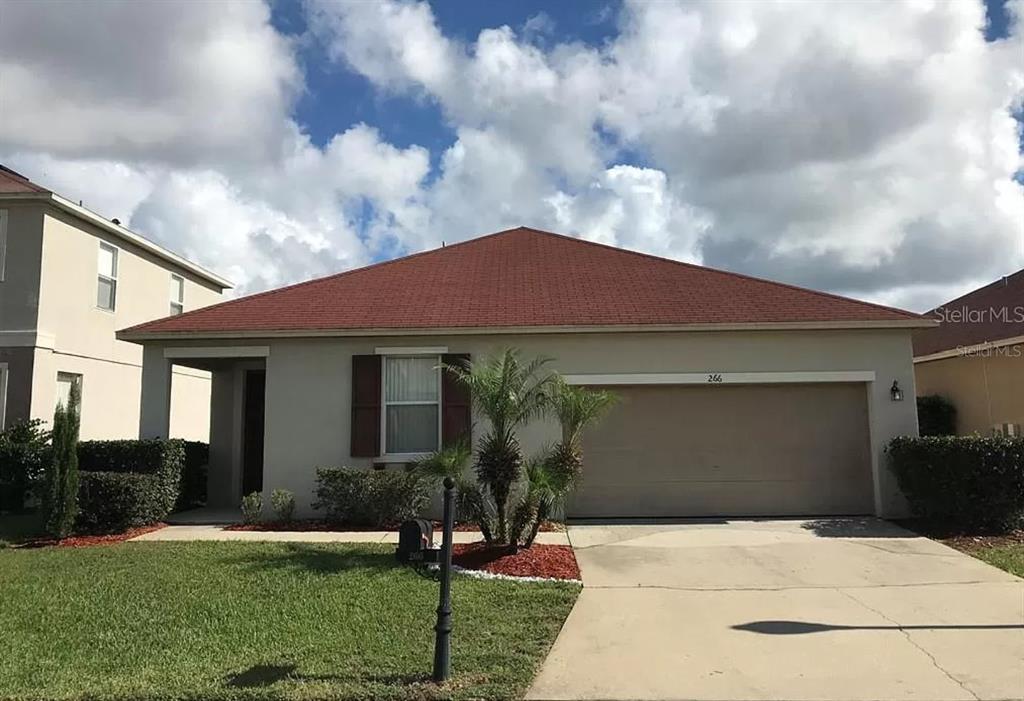 266 Sand Ridge Drive Davenport, FL 33896 - Photo 1 of 1 a front view of a house with garden