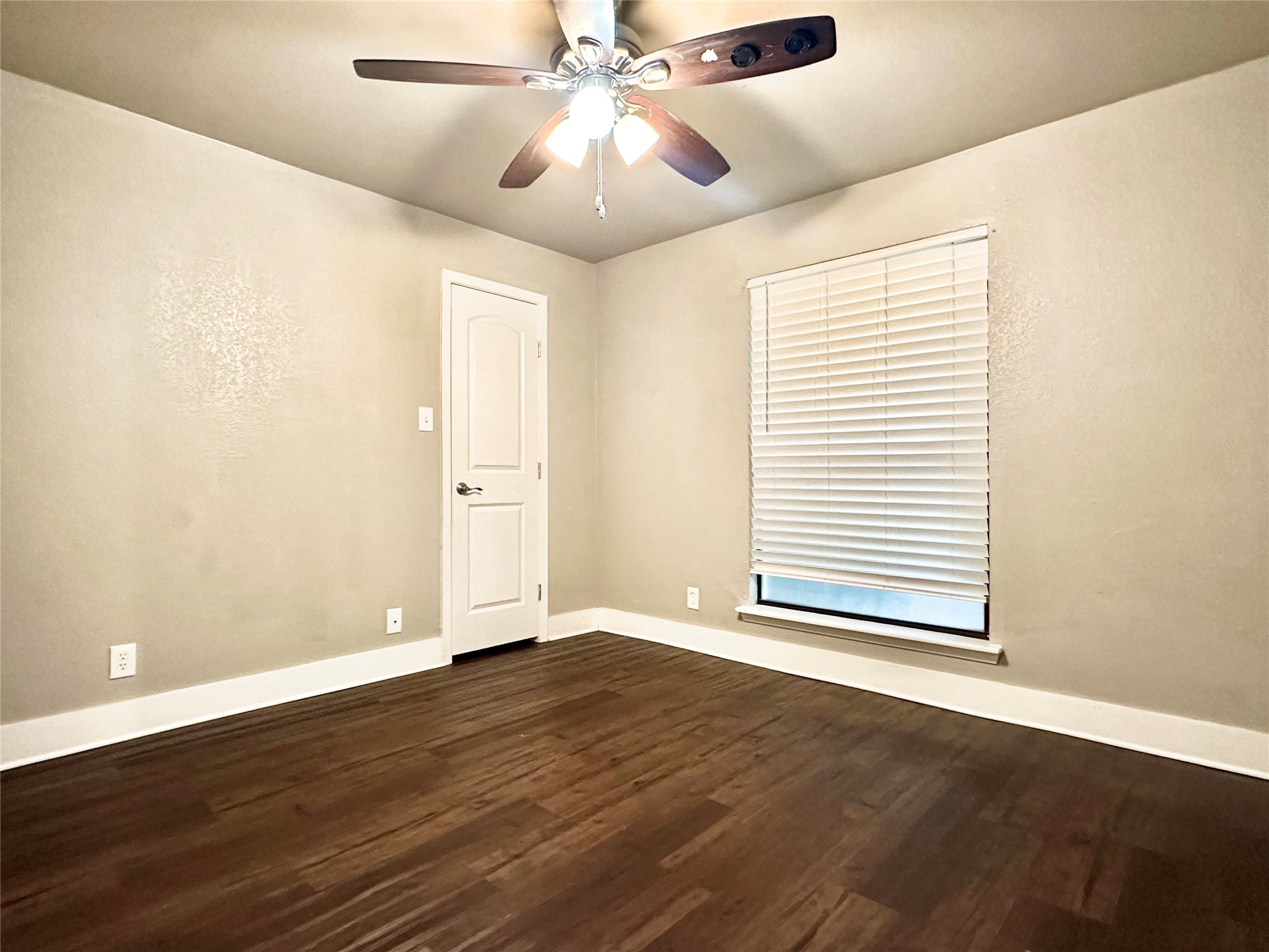 4316 Bull Creek Road, Unit 111 Austin, TX 78731 - Photo 6 of 8 This room features dark wood flooring, a window with blinds, and a ceiling fan with integrated lighting