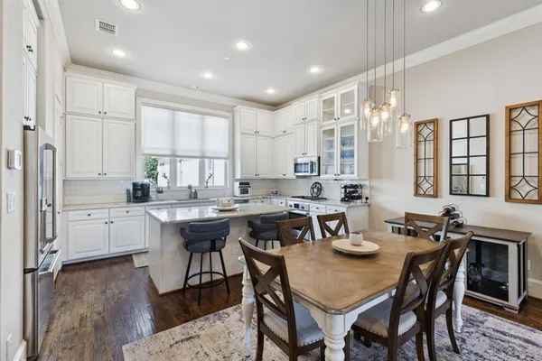 a kitchen with a table chairs sink and cabinets