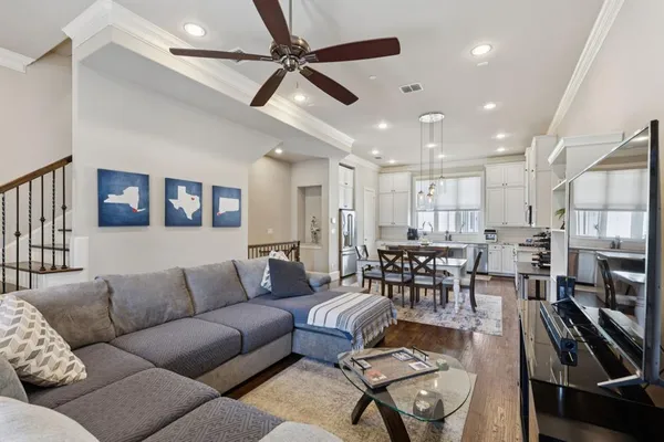 a living room with furniture kitchen view and a chandelier