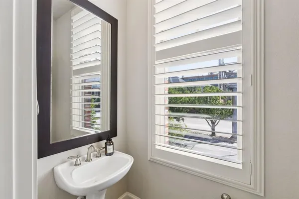a bathroom with a sink a mirror and a window