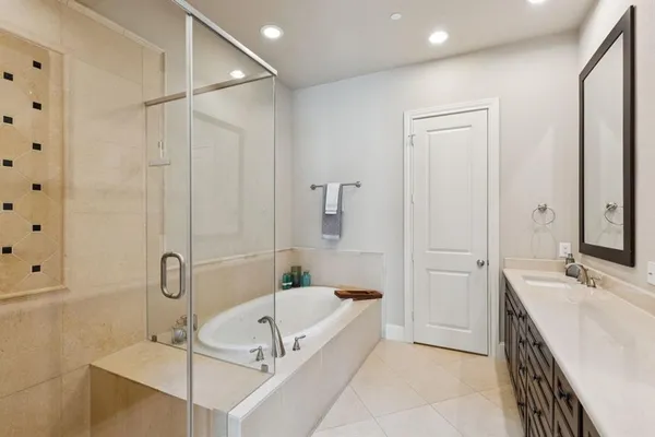 a bathroom with a tub sink and mirror