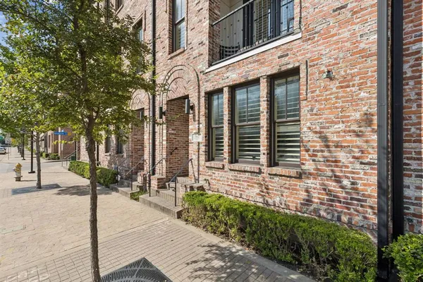 a brick building with a tree in front