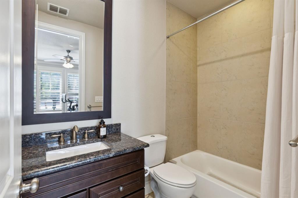 561 South Cesar Chavez Boulevard Dallas, TX 75201 - Photo 7 of 40 a bathroom with a granite countertop sink toilet a mirror and shower