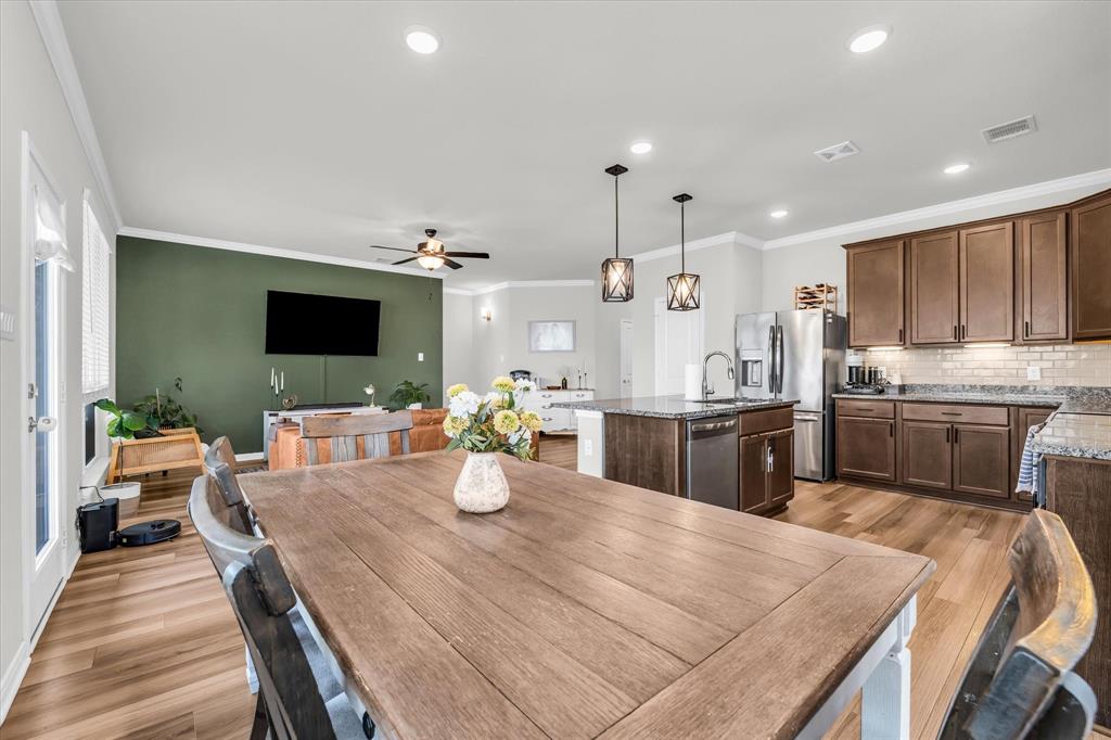 7008 Llano Drive China Spring, TX 76633 - Photo 11 of 26 a kitchen with a dining table chairs sink and white appliances
