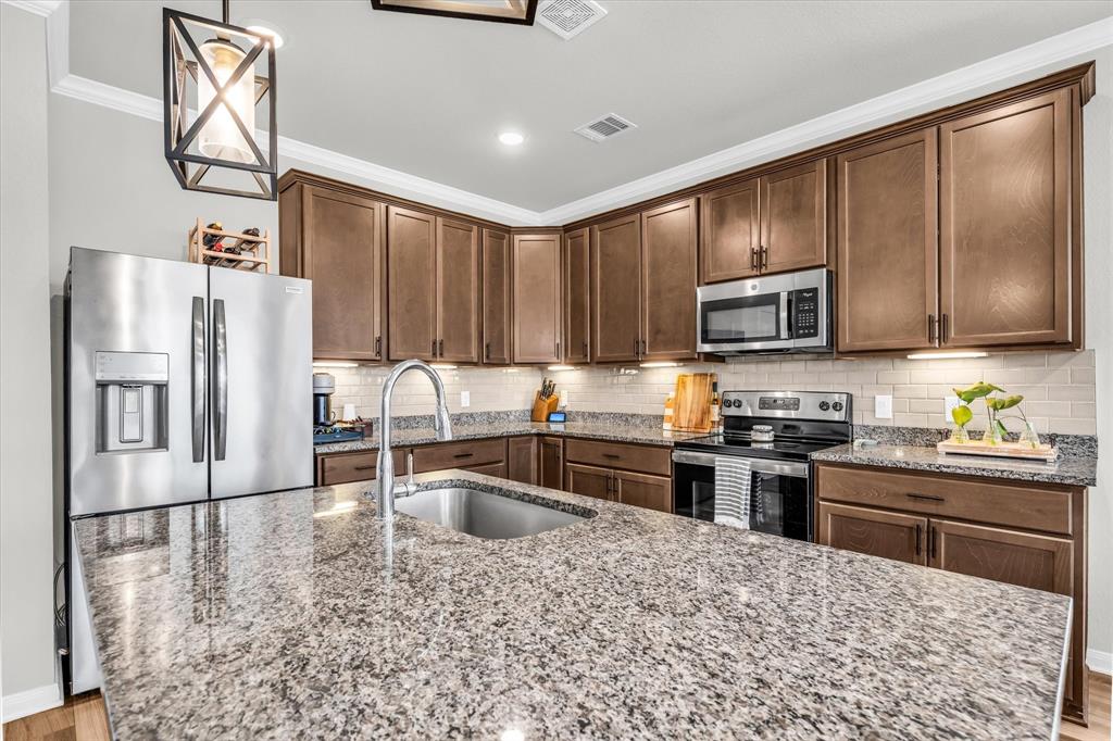 7008 Llano Drive China Spring, TX 76633 - Photo 7 of 26 a kitchen with stainless steel appliances granite countertop a refrigerator sink and stove