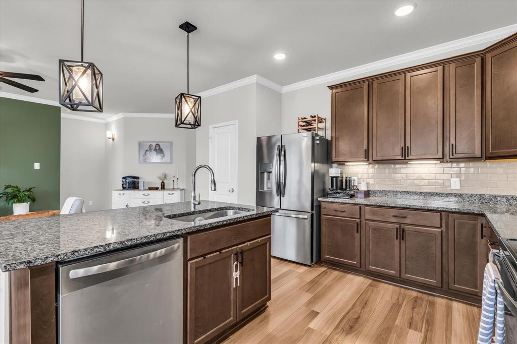 7008 Llano Drive China Spring, TX 76633 - Photo 8 of 26 a kitchen with stainless steel appliances granite countertop a sink a stove cabinets and wooden floor